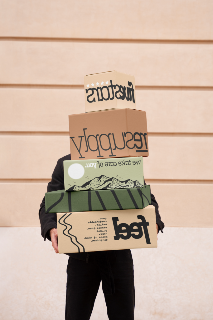 A person holding several resupply boxes of medical equipment.